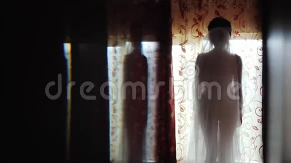 早上穿着漂亮的内衣新娘窗前的剪影视频的预览图