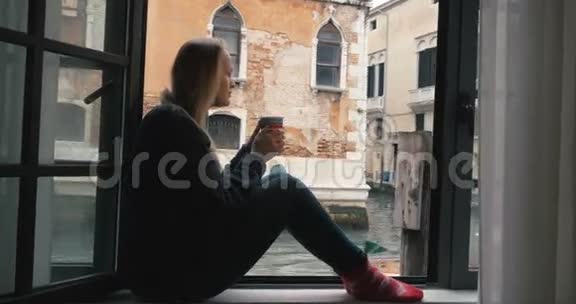 女人喝咖啡看威尼斯风景视频的预览图