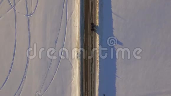 鸟瞰雪域和道路在冻土带的路上的车俯视视频的预览图
