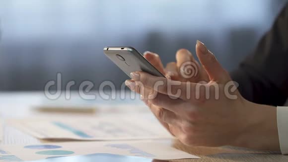 女商人在手机上滚动商业应用特写视频的预览图