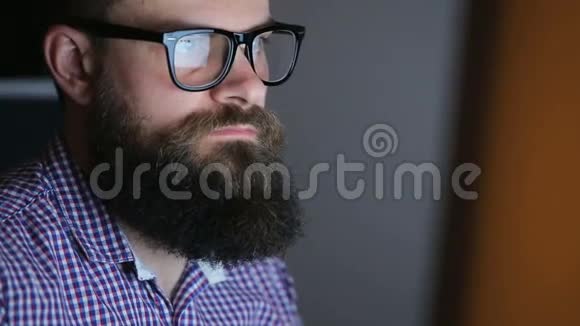 在电脑前工作的一个满脸胡须的疲惫青年视频的预览图