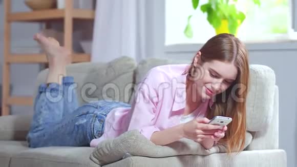 漂亮的女孩躺在客厅的沙发上视频的预览图