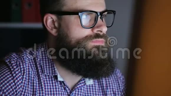 在电脑前工作的一个满脸胡须的疲惫青年视频的预览图