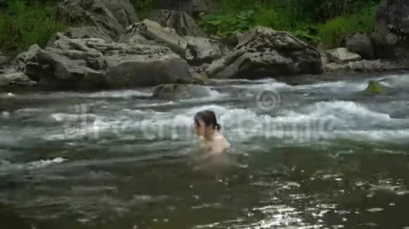 女人在河里洗澡一个年轻漂亮的女人沐浴在干净的山河里她很开心视频的预览图