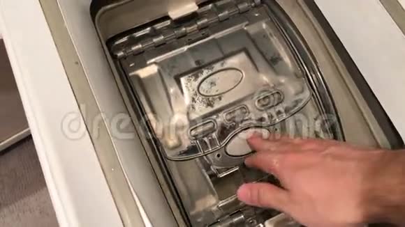 人打开一台立式洗衣机的门抽出洗衣房视频的预览图
