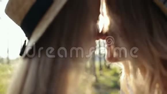 日落时分穿着白色连衣裙和草帽在树林里玩耍的母亲和女儿快乐视频的预览图