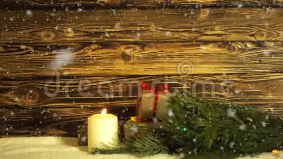 一支燃烧的蜡烛一根裘皮树枝还有一个礼品盒放在刷过的竹筒上视频的预览图