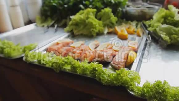 烤红鲑鱼加沙拉桌上放着青菜和柠檬的煮熟的鱼片美食节上烤鱼视频的预览图