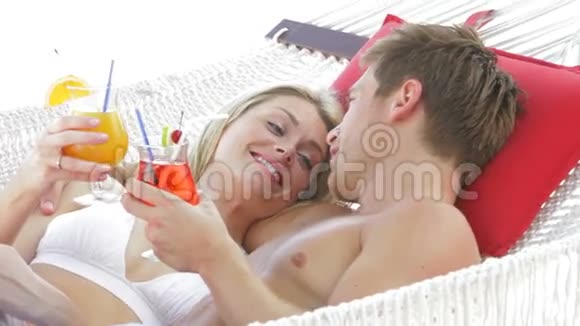 浪漫的情侣在沙滩吊床上放松视频的预览图
