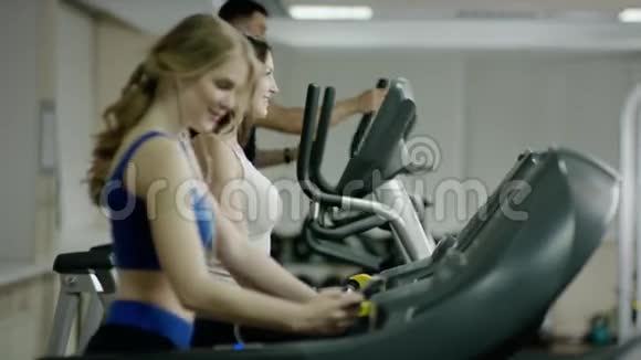 微笑着人们在跑步机上行走视频的预览图