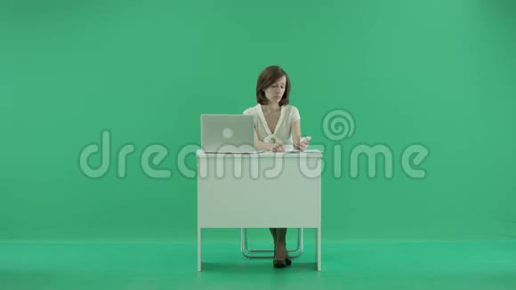 女人坐在桌子旁打电话视频的预览图