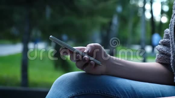 女性手特写使用智能手机通过触摸屏上的信息电话屏幕显示视频的预览图
