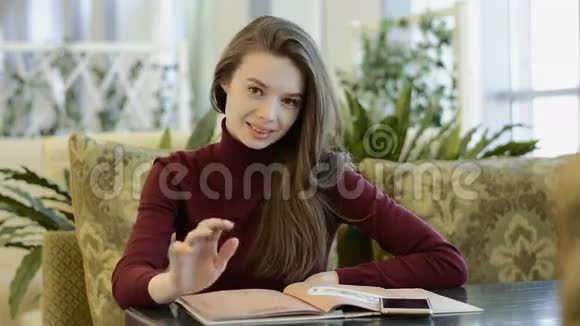 年轻漂亮的女人在咖啡馆里读菜单视频的预览图