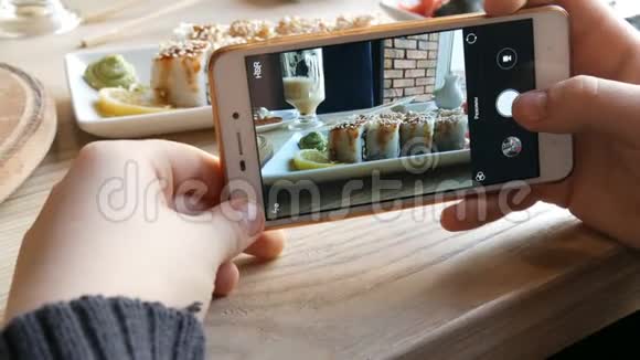 青少年的手在智能手机上制作食物的照片背景上日本料理的寿司卷视频的预览图