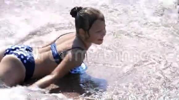 微笑快乐的八岁女孩穿着泳装在街头喷泉户外公园夏天的飞溅中玩得开心视频的预览图