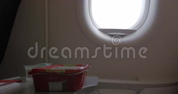 特写一段女人吃飞机餐时用塑料叉子抵着窗上升蔬菜视频的预览图