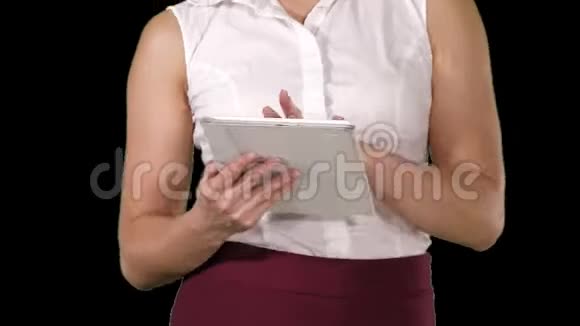 女人拿着数字平板电脑走路时用它阿尔法频道视频的预览图
