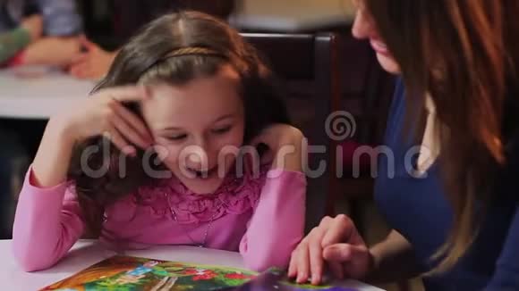快乐的小女孩女儿读孩子书聊天妈妈视频的预览图