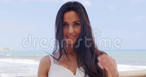 年轻貌美的女士斜倚沙滩栏杆视频的预览图