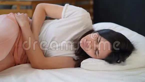 坐在家里睡觉时腹痛的年轻妇女视频的预览图