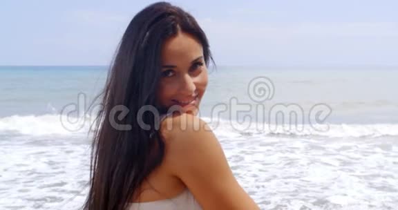 西班牙裔白人年轻女士在海滩上享受视频的预览图