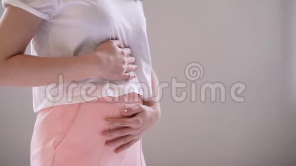 坐在家里睡觉时腹痛的年轻妇女视频的预览图