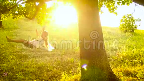 一个长发女孩在公园的树上荡秋千视频的预览图