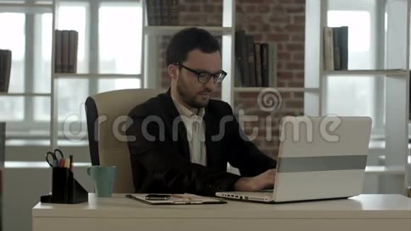 商人用键盘敲他的滑稽眼镜视频的预览图