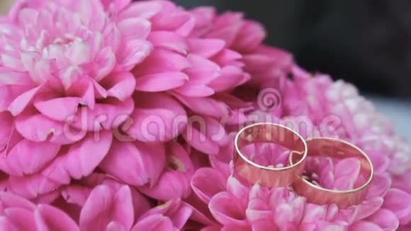 结婚戒指上有粉色的花婚礼的属性背景视频的预览图