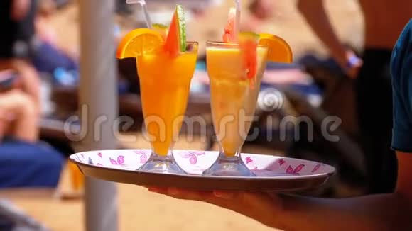 服务员在埃及海滩上供应饮料服务员拿着带热带果汁的托盘视频的预览图