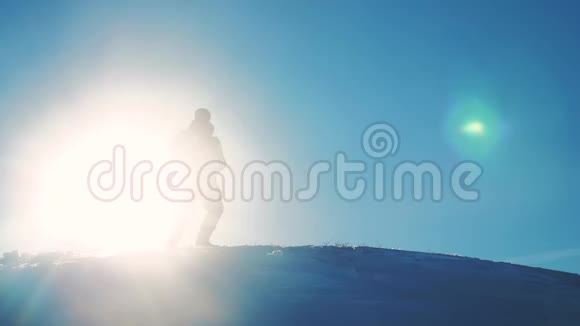 男子旅行者在冬季登山剪影阳光慢动作视频旅行冒险冬季雪概念视频的预览图
