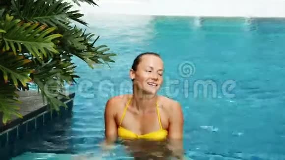 穿黄色泳衣的女孩在大游泳池里私营视频的预览图