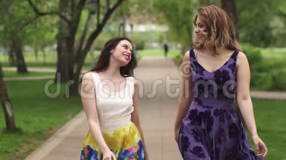 迷人的女孩穿过公园微笑女朋友花时间在户外明亮的夏天女孩视频的预览图