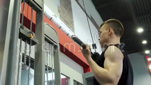 强壮年轻英俊的男性健美运动员在健身房锻炼身体视频的预览图