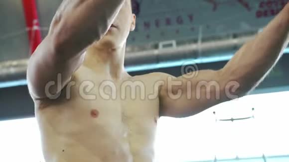 强壮的年轻英俊的男性运动员在健身房训练肩膀肌肉视频的预览图