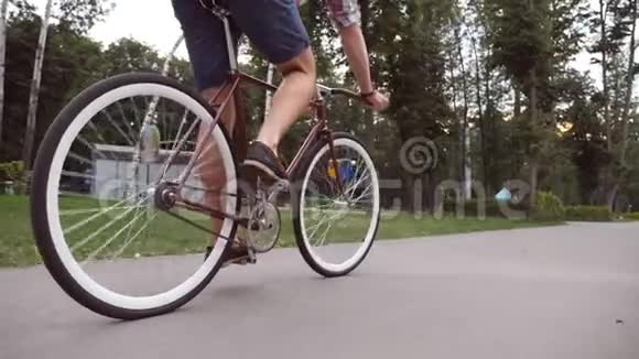 年轻人在公园路上骑着一辆老式自行车运动的家伙在户外骑自行车健康的积极生活方式低角度视频的预览图