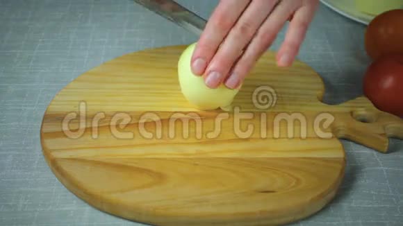 厨师在木板上切一块黄色洋葱视频的预览图