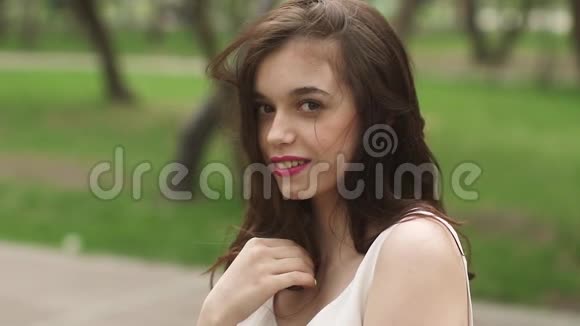 年轻迷人的女孩带着美丽微笑的肖像模特看着相机微笑在明亮的夏天的女孩视频的预览图