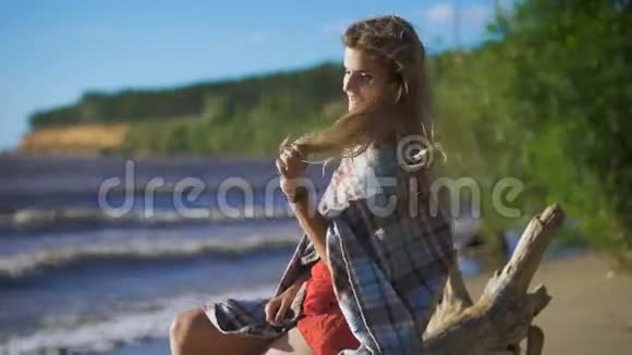 坐在木头上的漂亮女孩旅行和假期自由概念性感金发美女视频的预览图