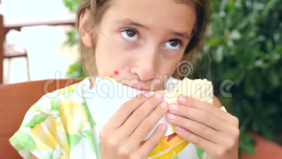 一个漂亮的女孩坐在一家快餐店里吃着新鲜的皮塔面包里面有新鲜的蔬菜和肉沙拉视频的预览图