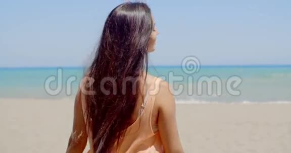 海滩上一位长座女士的后景视频的预览图