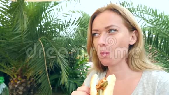 一个漂亮的女孩坐在一家快餐店里吃着新鲜的皮塔面包里面有新鲜的蔬菜和肉沙拉视频的预览图