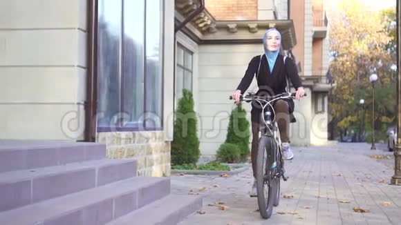 年轻的穆斯林妇女戴头巾骑自行车视频的预览图