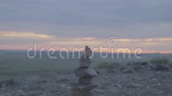 卵石塔禅和平衡石头堆在天空上田野背景上的石塔视频的预览图