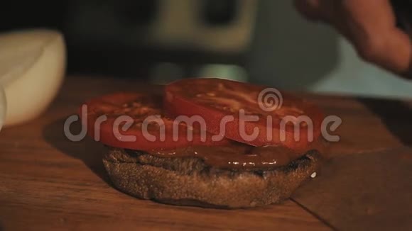 男性厨师长做白袍做汉堡包把烤肉放在西红柿上视频的预览图