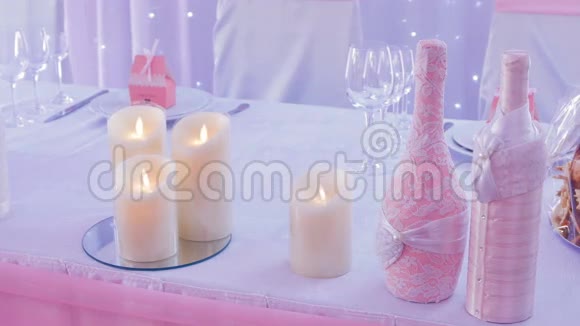 餐桌上的婚礼装饰蜡烛和两瓶视频的预览图
