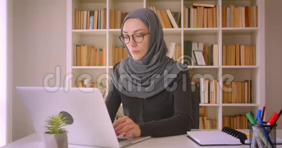 在室内使用笔记本电脑拍摄的穆斯林年轻女商人戴头巾的特写照片视频的预览图