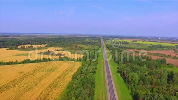 无人机在成熟的黑麦地之间飞过高速公路视频的预览图