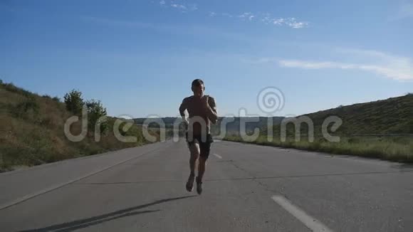 冲刺跑步者在高速公路上慢跑男子体育运动员夏季户外训练年轻强壮肌肉男视频的预览图