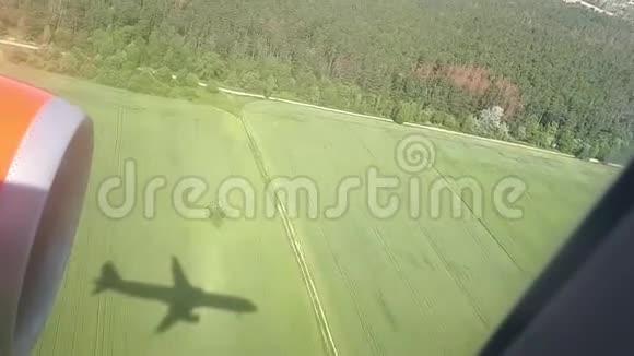 晴天的地面上飞行飞机的影子从飞机窗口观看飞机的影子在空中飞行视频的预览图